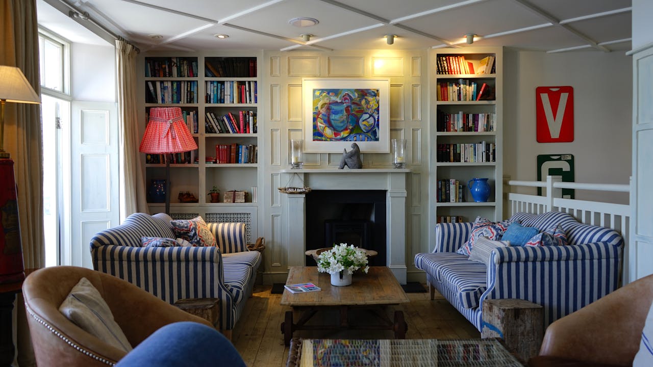 Stylish living room with modern decor, striped couches, and a cozy fireplace.